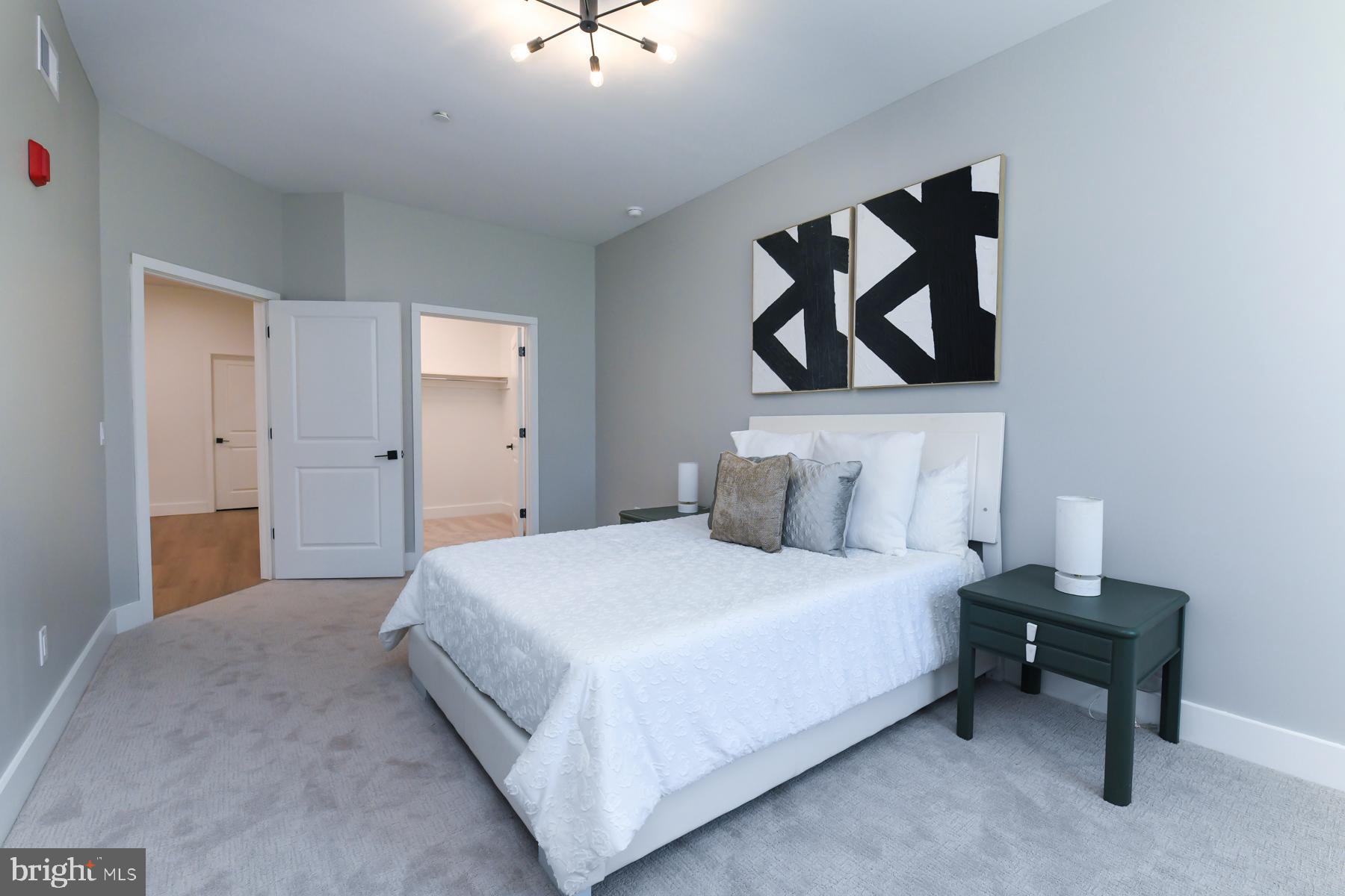 100 Aura Road, Unit 110 Clayton, NJ 08312 - Photo 14 of 21 a bedroom with a bed and a painting on the wall