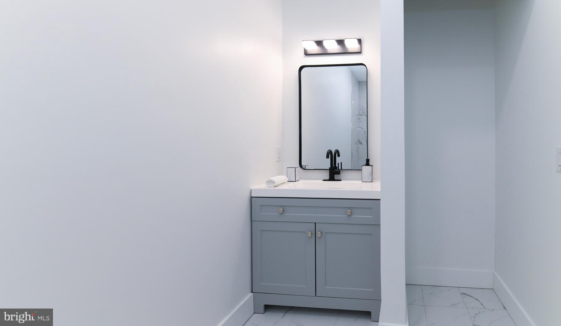 100 Aura Road, Unit 110 Clayton, NJ 08312 - Photo 17 of 21 a bathroom with a sink a mirror and vanity