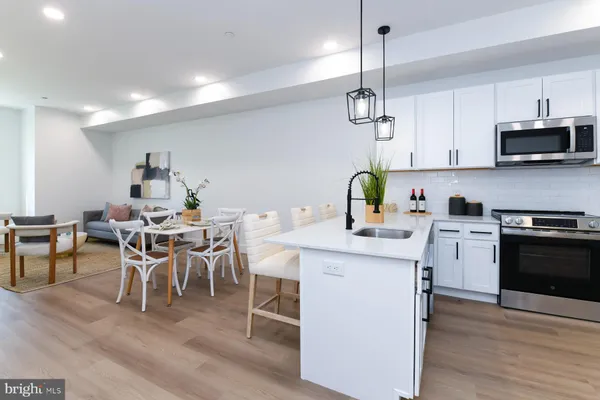 a kitchen with a dining table chairs stainless steel appliances and cabinets