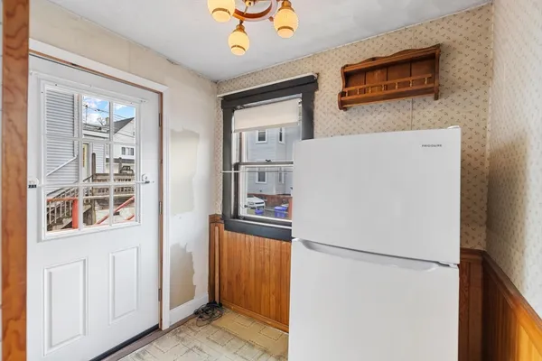 a view of a kitchen with refrigerator and wooden floor