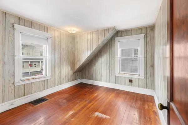 a view of an empty room with wooden floor and entryway