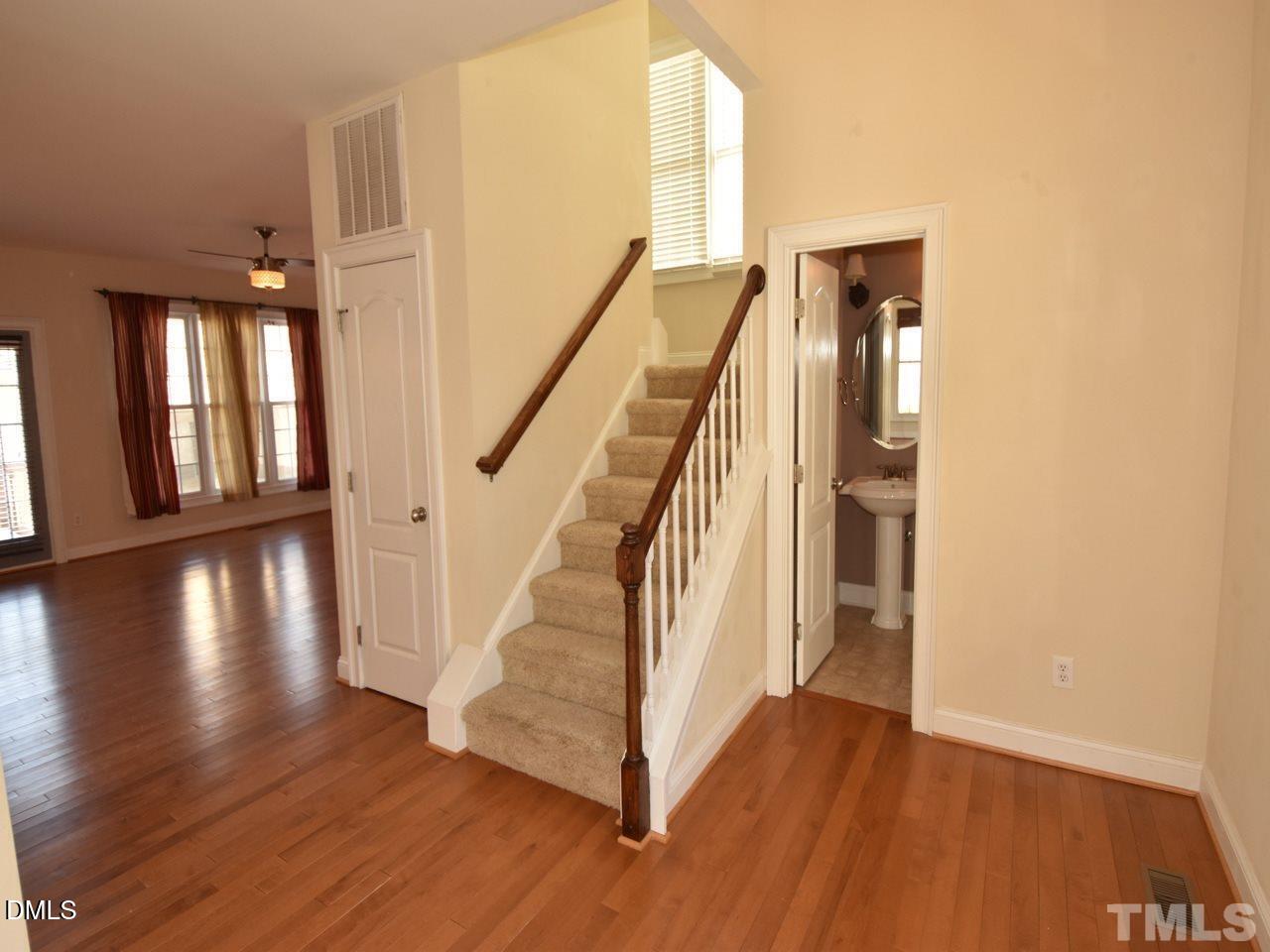 118 Fort Jackson Road Morrisville, NC 27560 - Photo 6 of 21 a view of a hallway with wooden floor and staircase