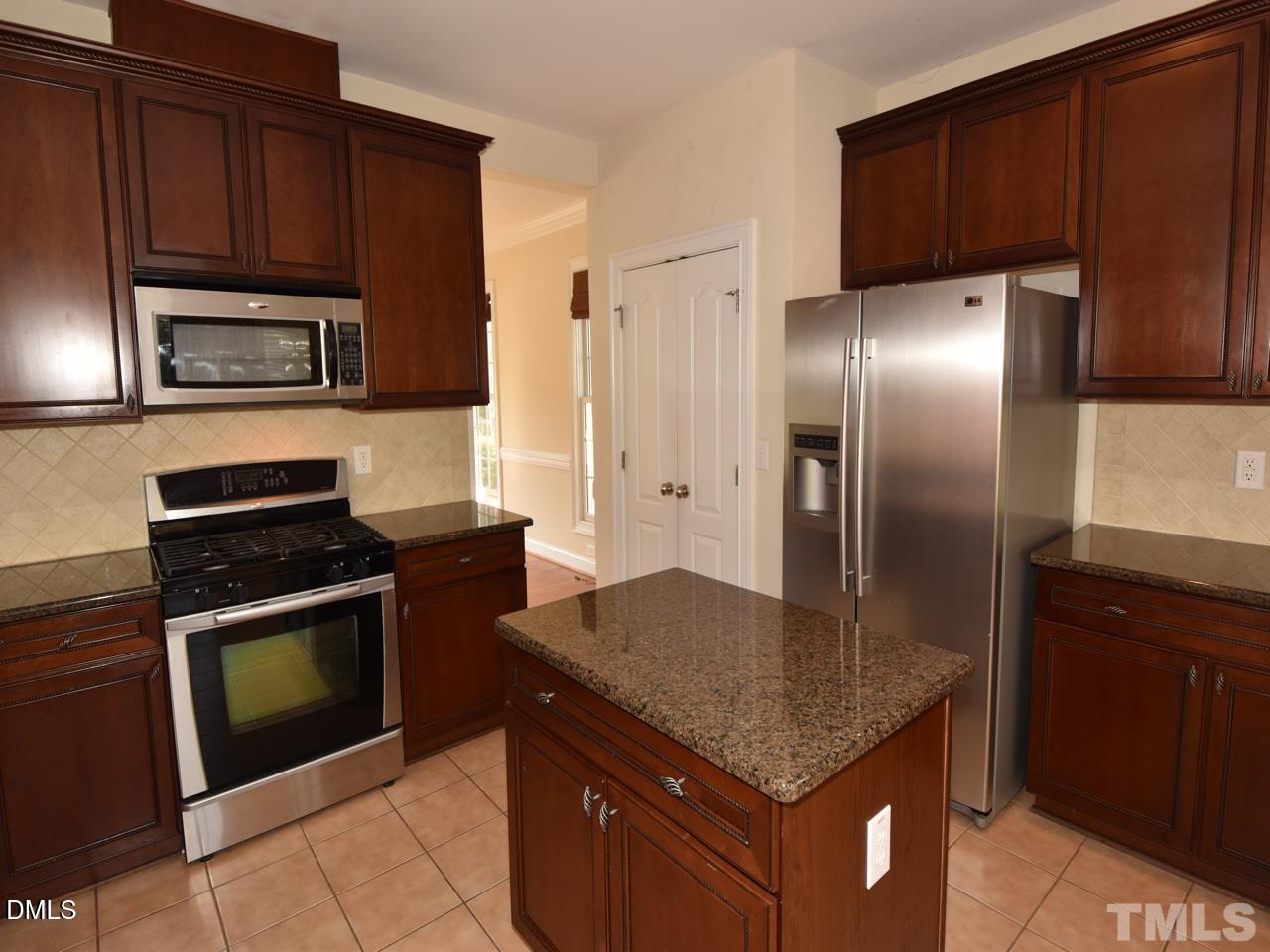 118 Fort Jackson Road Morrisville, NC 27560 - Photo 8 of 21 a kitchen with kitchen island granite countertop stainless steel appliances and wooden cabinets