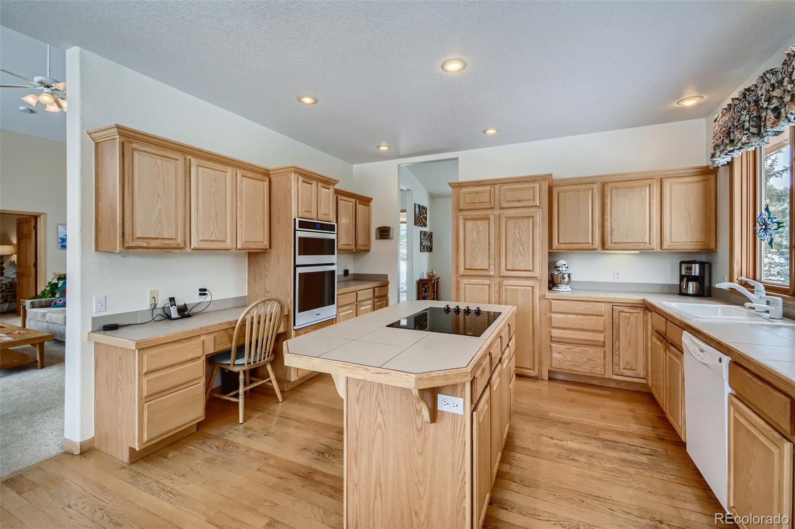 1634 Muirfield Lane Evergreen, CO 80439 - Photo 12 of 40 a kitchen with a stove a sink a refrigerator and cabinets