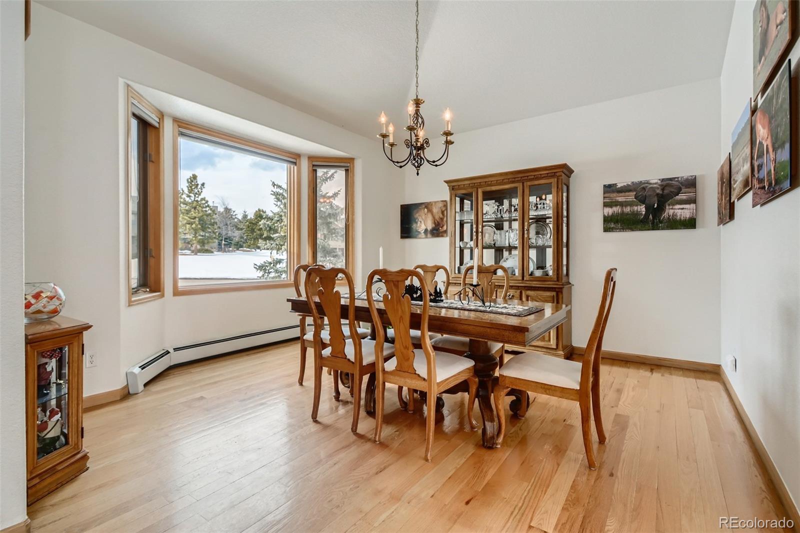1634 Muirfield Lane Evergreen, CO 80439 - Photo 14 of 40 a view of a dining room with furniture a chandelier and wooden floor