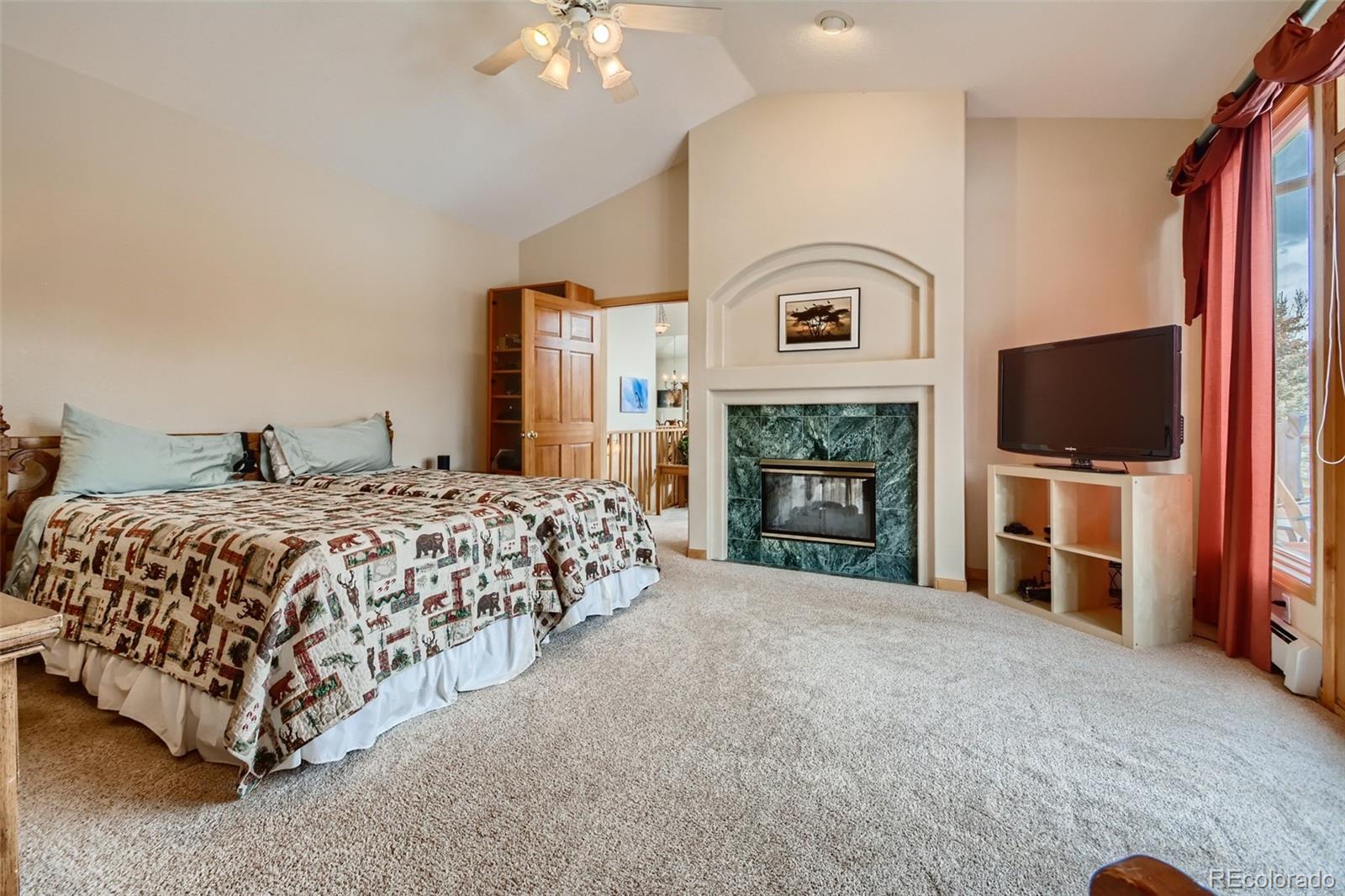 1634 Muirfield Lane Evergreen, CO 80439 - Photo 16 of 40 a spacious bedroom with a bed and a flat screen tv