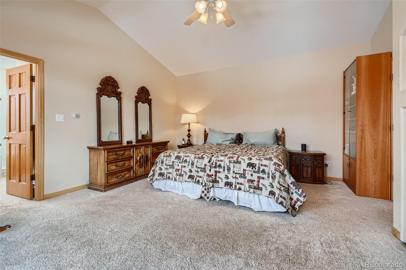 1634 Muirfield Lane Evergreen, CO 80439 - Photo 17 of 40 a bedroom with a bed and a chandelier
