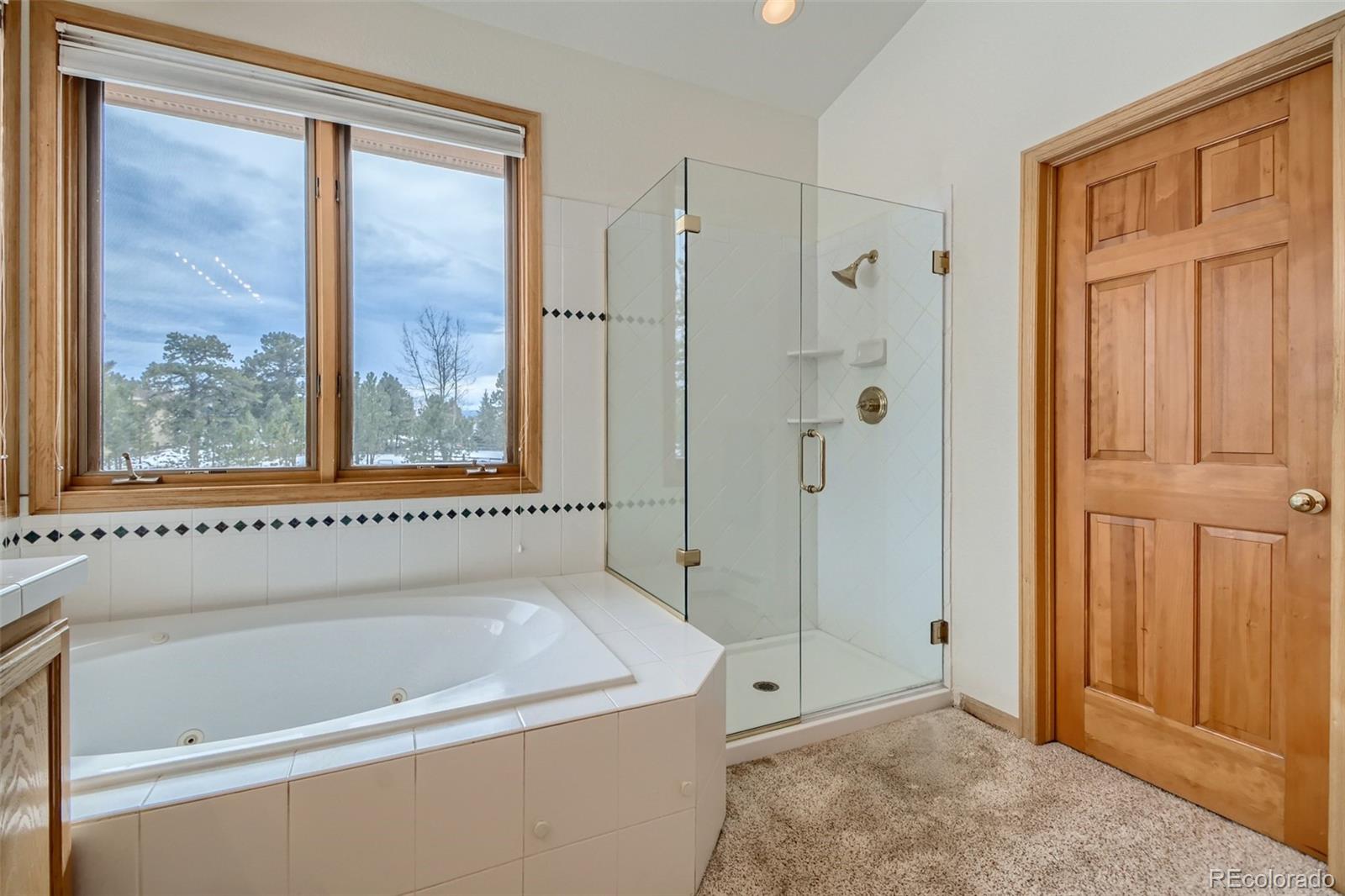 1634 Muirfield Lane Evergreen, CO 80439 - Photo 19 of 40 a bathroom with a bathtub and a shower
