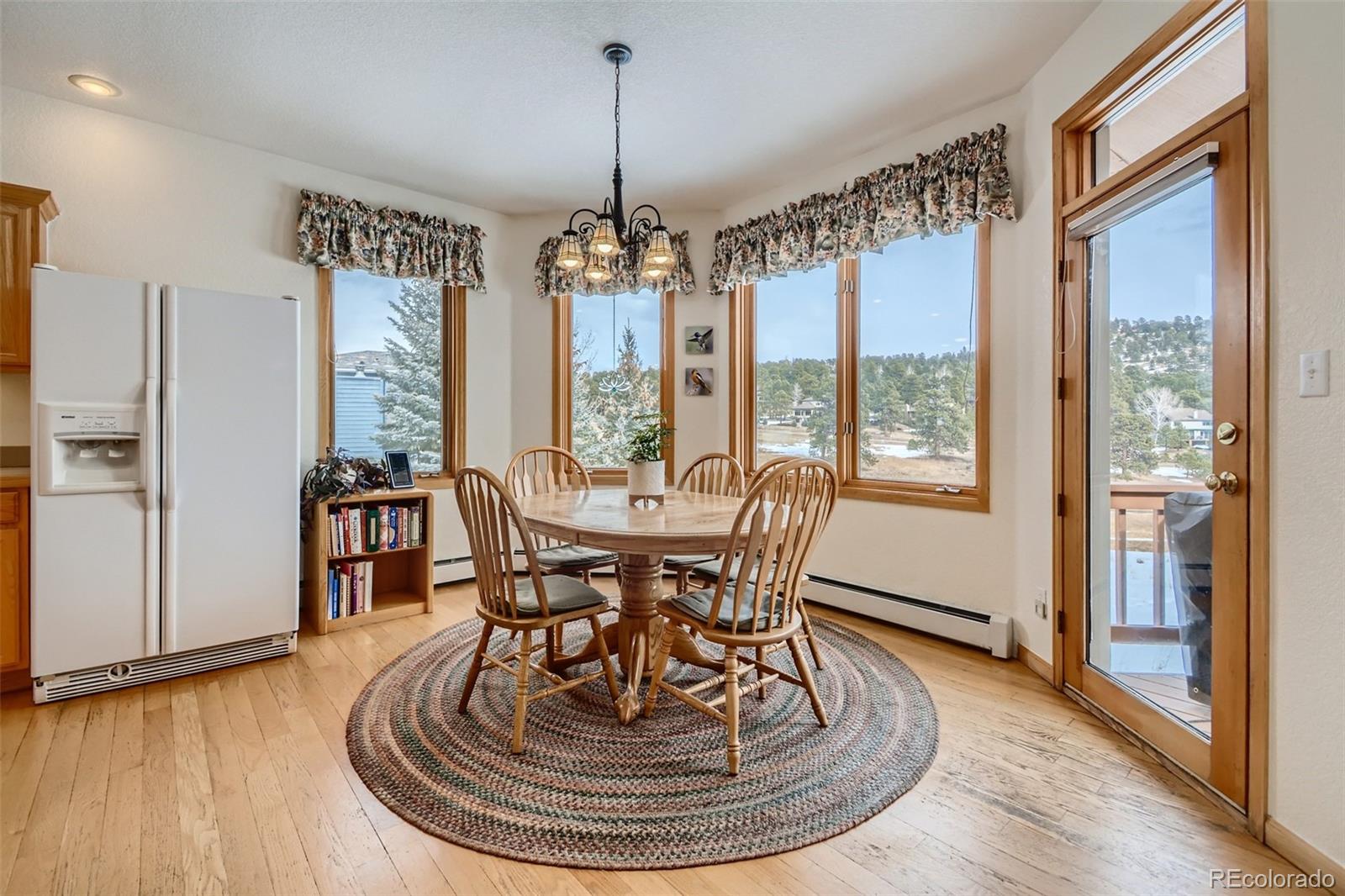 1634 Muirfield Lane Evergreen, CO 80439 - Photo 9 of 40 a view of a dining room with furniture window and wooden floor