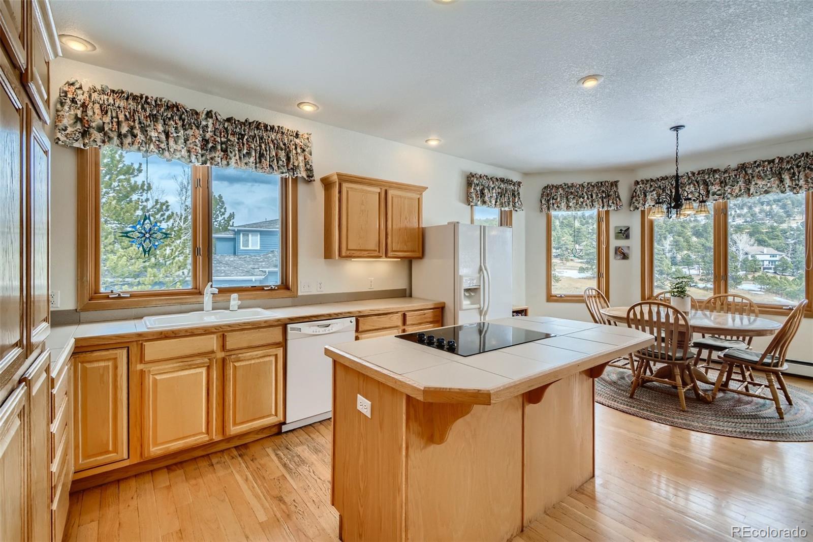 1634 Muirfield Lane Evergreen, CO 80439 - Photo 10 of 40 a kitchen with stainless steel appliances granite countertop sink stove and wooden cabinets