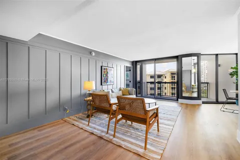 a living room with furniture and a floor to ceiling window