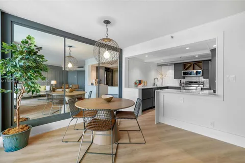a view of a dining room and livingroom with furniture wooden floor a chandelier