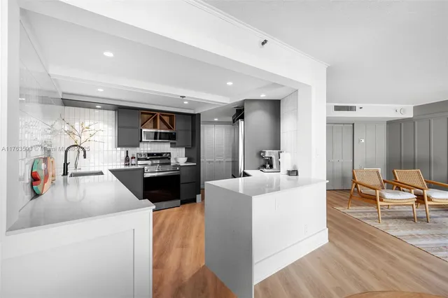 a large white kitchen with stainless steel appliances cabinets