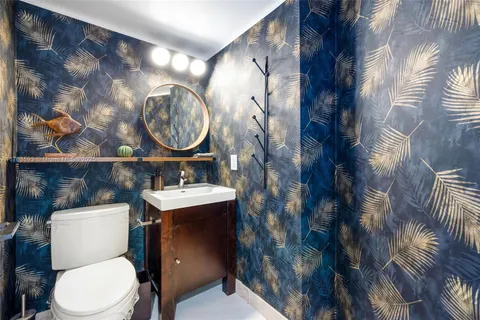 a bathroom with a sink mirror vanity and toilet