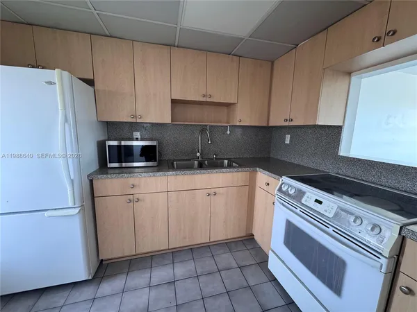 a kitchen with cabinets stainless steel appliances and sink
