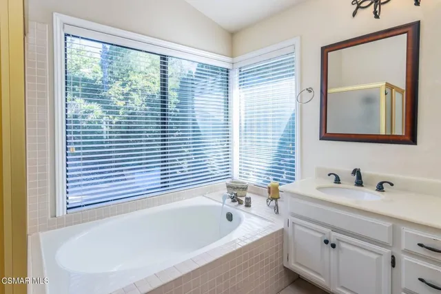 a bathroom with a bathtub a sink and a window