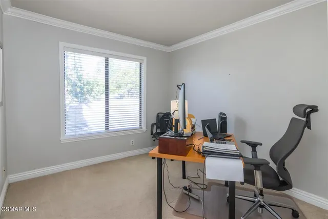 a view of a workspace with furniture and a window
