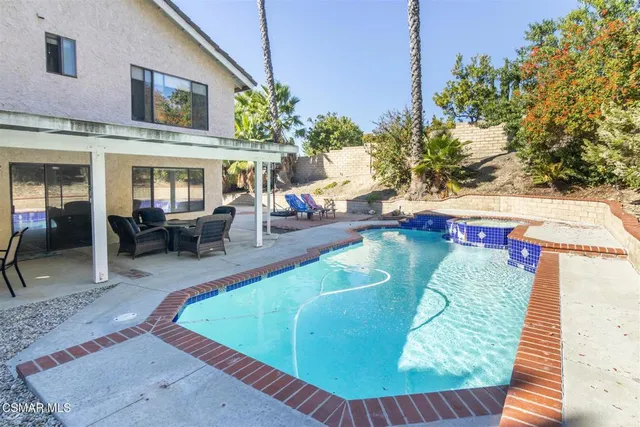 a view of a patio with a table chairs and a backyard
