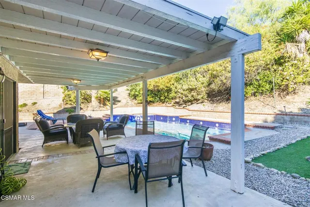 a view of a house with backyard and sitting area