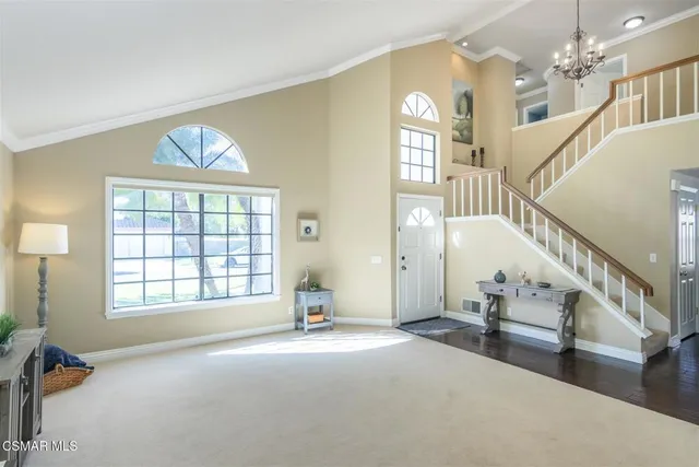 a view of empty room with stairs and windows