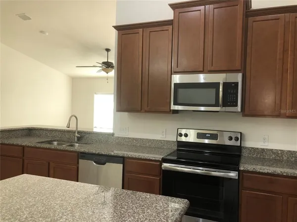 a kitchen with granite countertop a stove and a sink