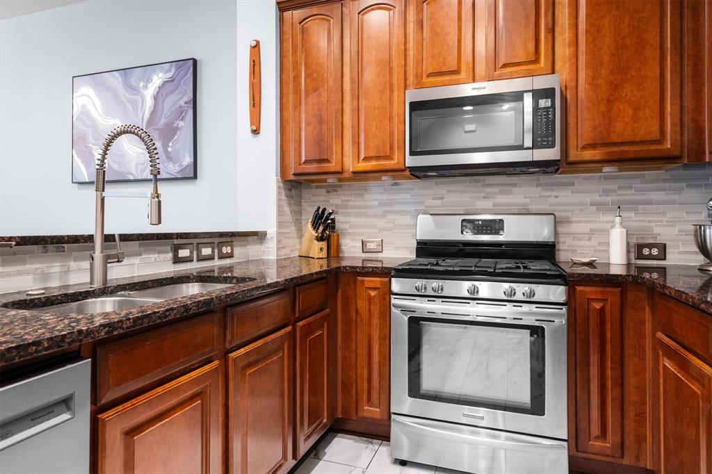 5019 Morris Avenue, Unit 22 Addison, TX 75001 - Photo 10 of 31 a kitchen with stainless steel appliances granite countertop a stove microwave and sink
