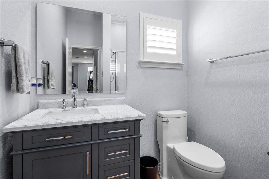 5019 Morris Avenue, Unit 22 Addison, TX 75001 - Photo 17 of 31 a bathroom with a granite countertop toilet sink and mirror
