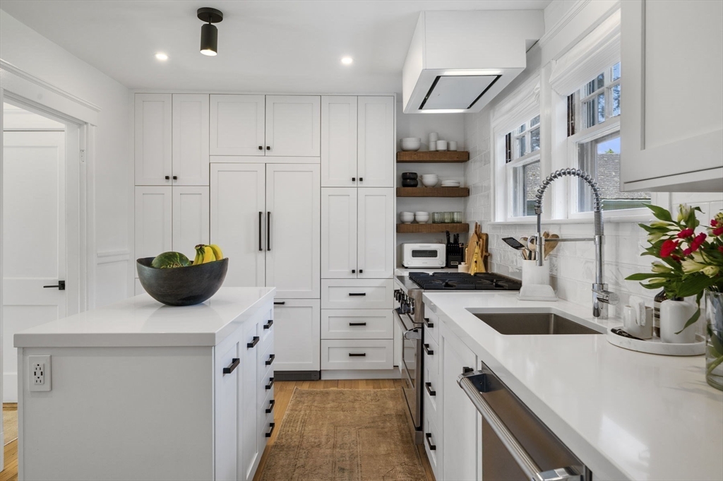 5 Chesterlee Lane Swampscott, MA 01907 - Photo 11 of 42 a kitchen with stainless steel appliances white cabinets a sink a stove and a wooden floors