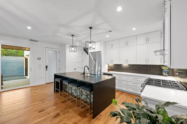 a living room with kitchen island granite countertop furniture and wooden floor