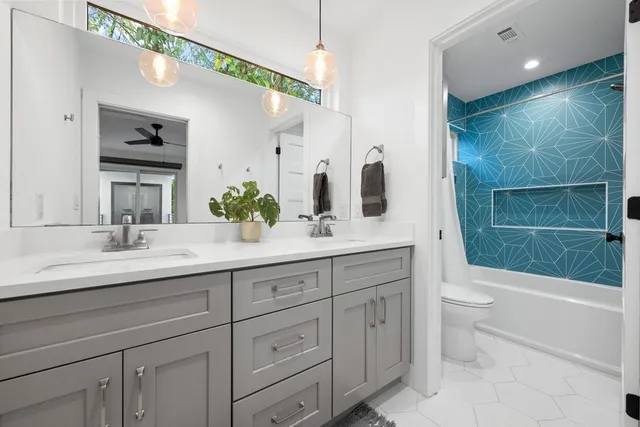 a bathroom with a sink a toilet and shower