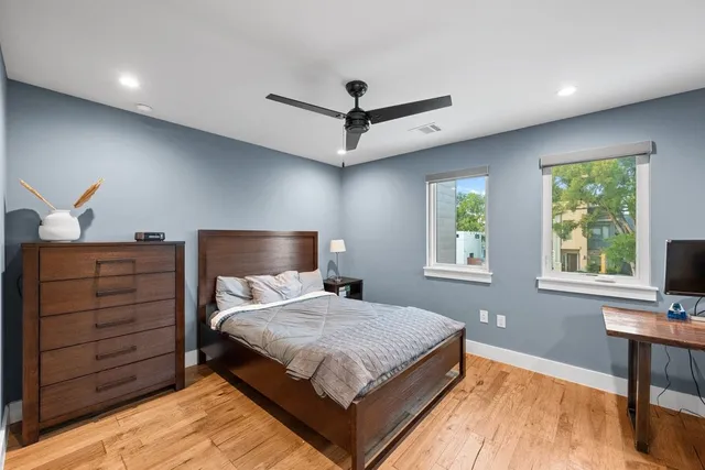 a bedroom with a large bed and a flat tv screen on dresser