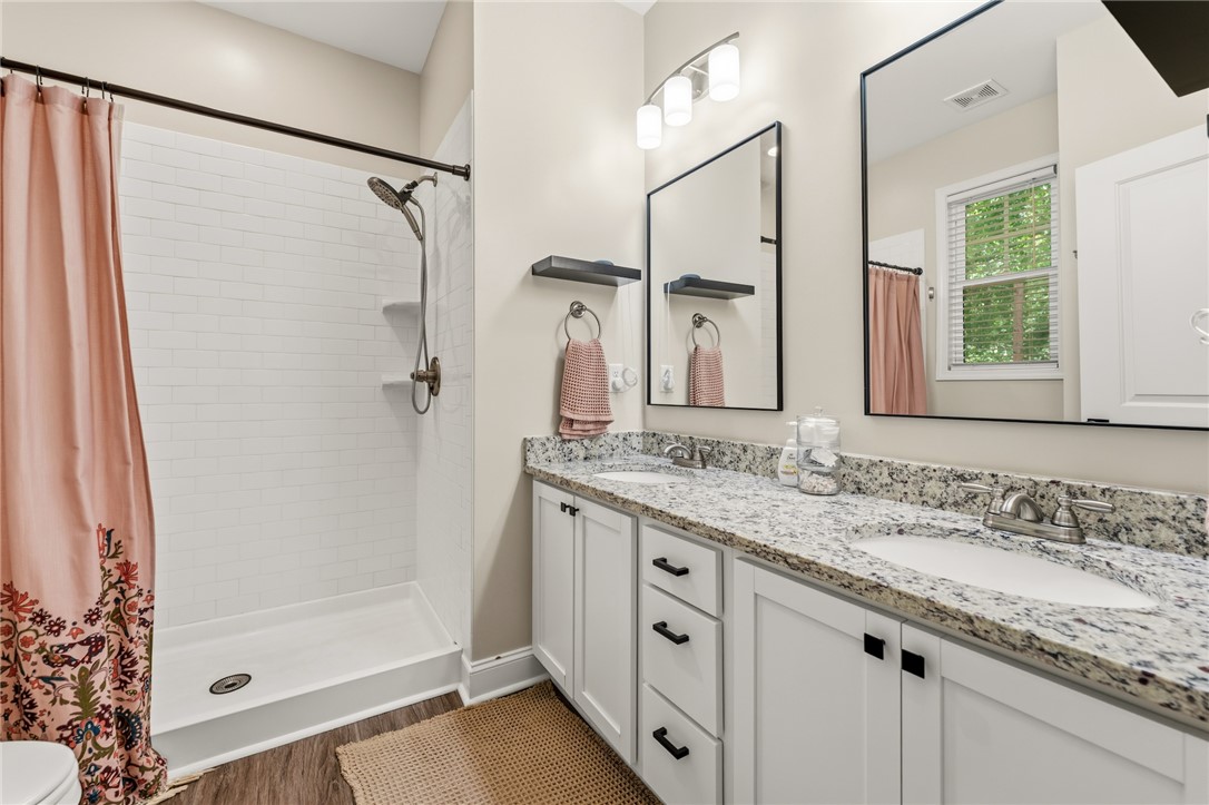 47 A Main Street Pelzer, SC 29669 - Photo 18 of 27 This primary bathroom features a double vanity with ample counter space and a modern shower.