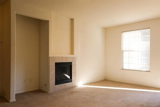an empty room with windows and fireplace