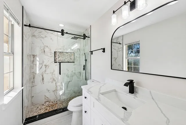 an empty room with wooden floor cabinet and windows