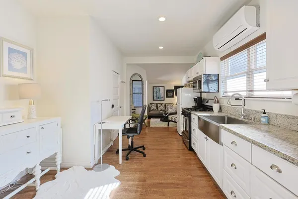 a large white kitchen with lots of counter top space and windows