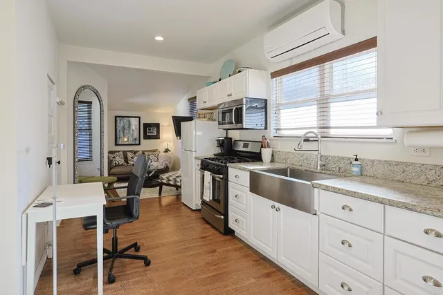 a kitchen with stainless steel appliances granite countertop a stove top oven a sink a dining table and chairs