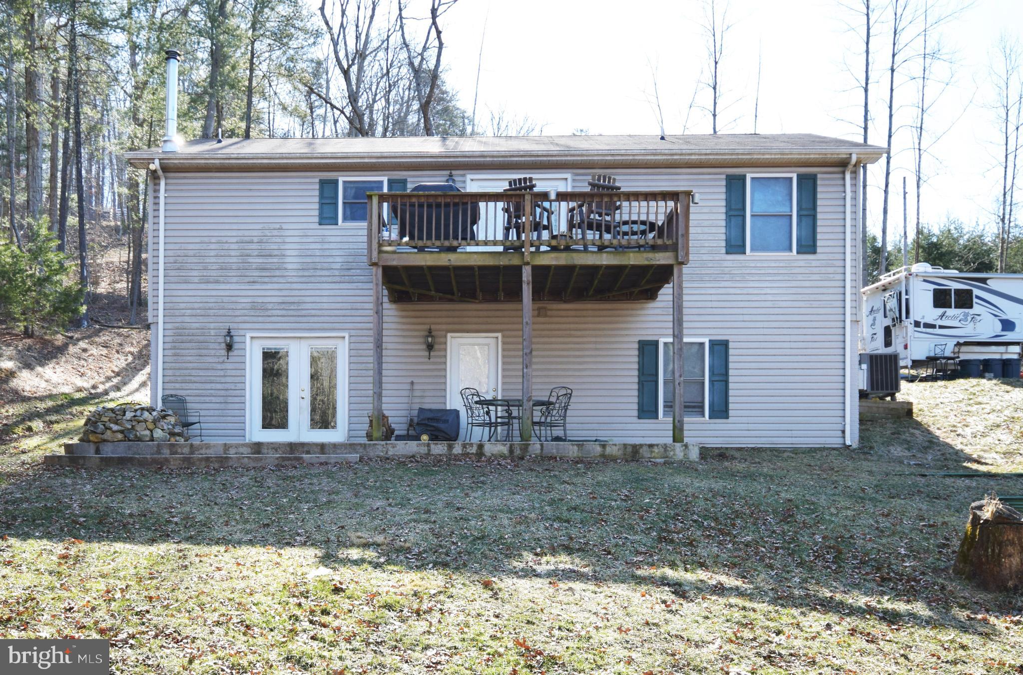 97 Spring Hollow Road Front Royal, VA 22630 - Photo 11 of 38 a view of a stone house with a yard and large tree
