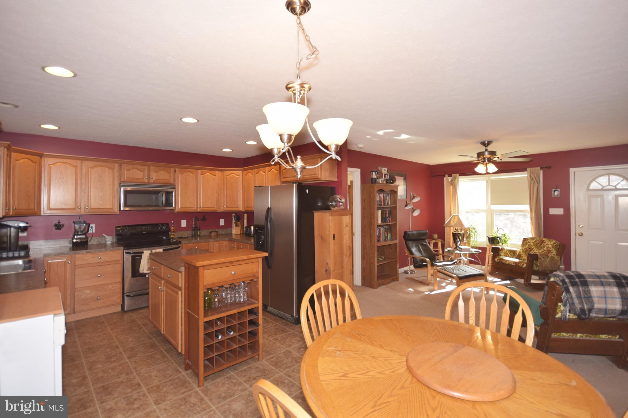 97 Spring Hollow Road Front Royal, VA 22630 - Photo 17 of 38 a kitchen with stainless steel appliances kitchen island granite countertop a refrigerator a stove top oven a sink and a dining table with the kitchen view
