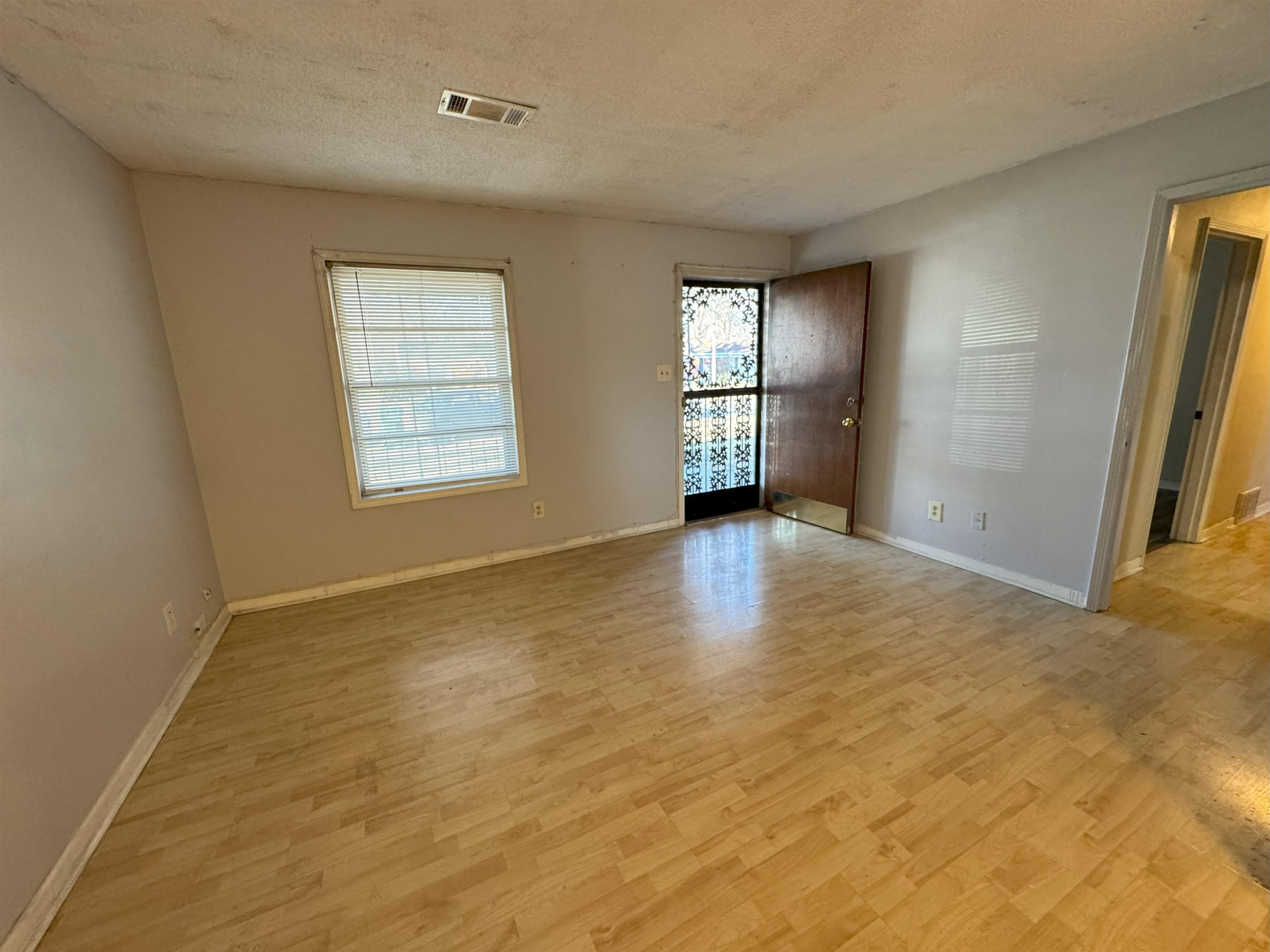 4783 Owen Road Memphis, TN 38122 - Photo 5 of 16 a view of an empty room with a window and wooden floor
