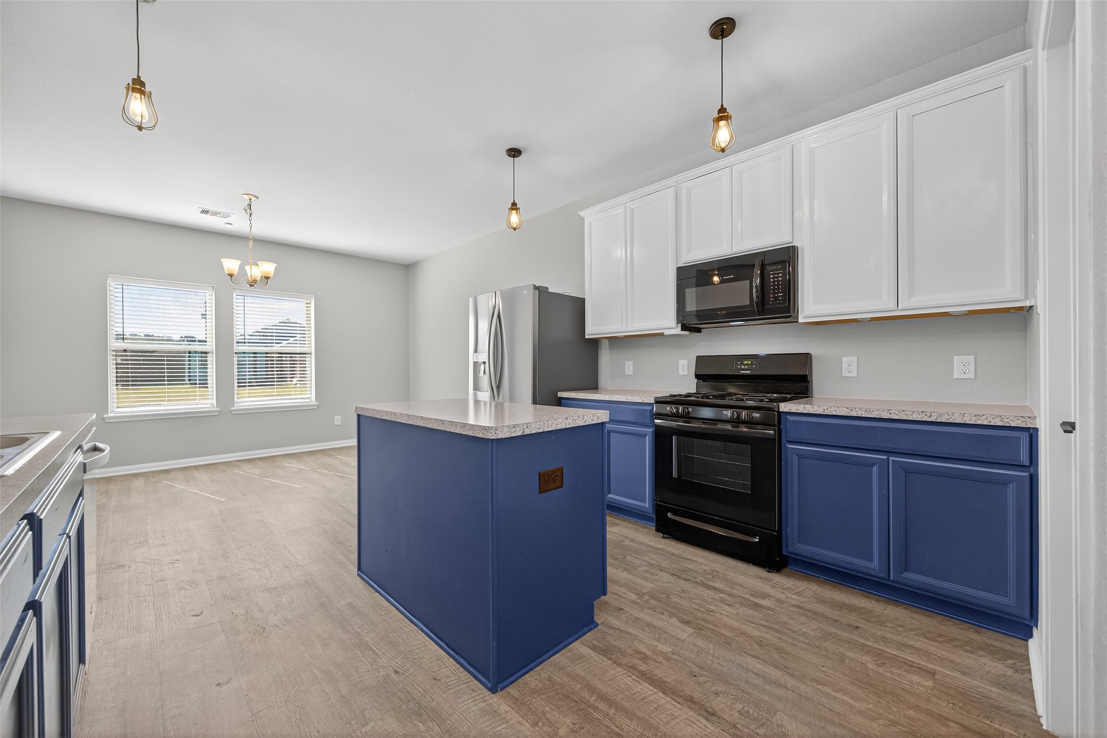 26108 Morgan Cemetery Road Cleveland, TX 77328 - Photo 12 of 39 a large kitchen with stainless steel appliances granite countertop a stove a sink dishwasher a microwave oven and a refrigerator with wooden cabinets