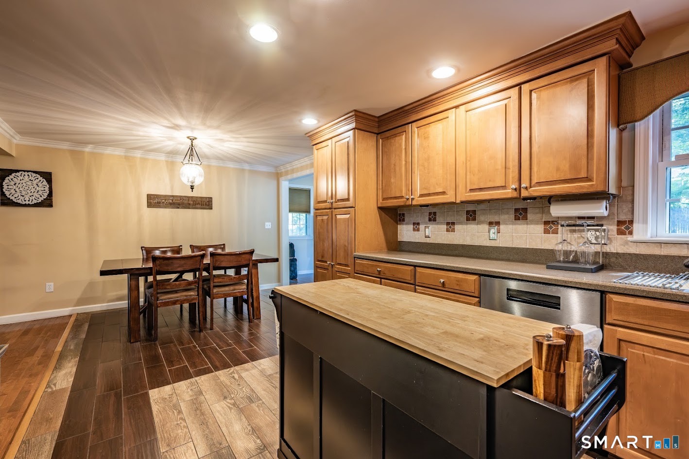 144 Goff Road Wethersfield, CT 06109 - Photo 8 of 26 Updated kitchen with warm wood cabinetry, stainless steel appliances, tile backsplash, recessed lighting, and an adjoining dining area for easy everyday living.