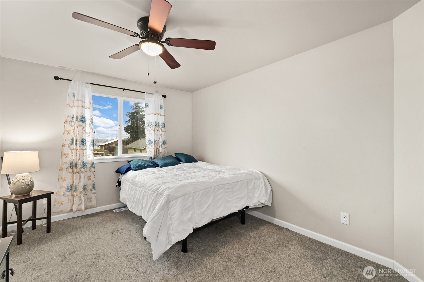3626 East Howe Street Tacoma, WA 98404 - Photo 16 of 28 a bedroom with a bed a chandelier and a window