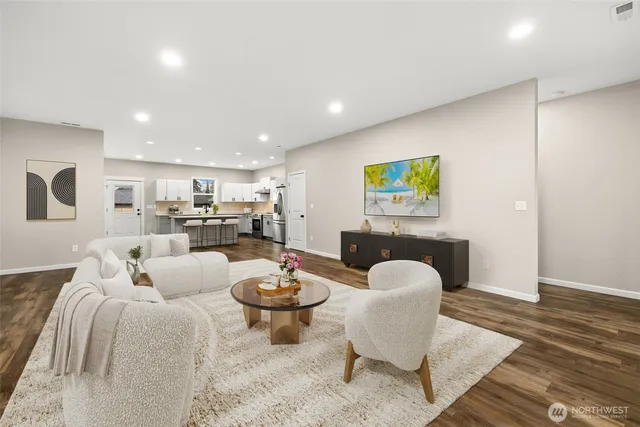a living room with furniture kitchen view and a table