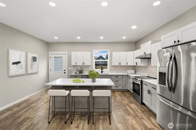 a kitchen with a table chairs refrigerator and microwave