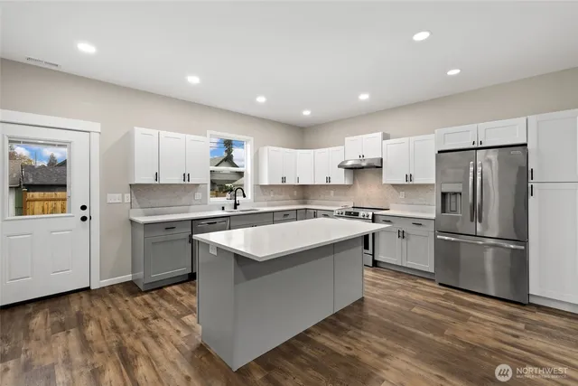 a kitchen with a refrigerator sink and cabinets