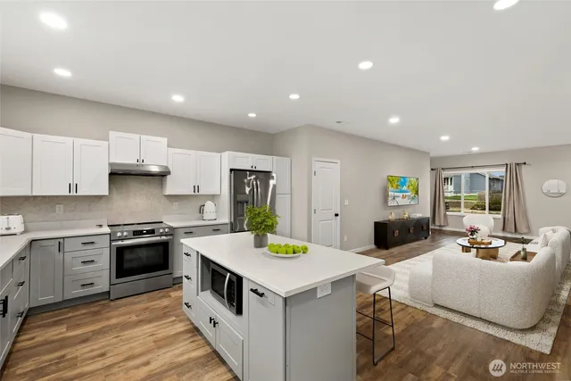 a kitchen that has a lot of cabinets in it and wooden floors
