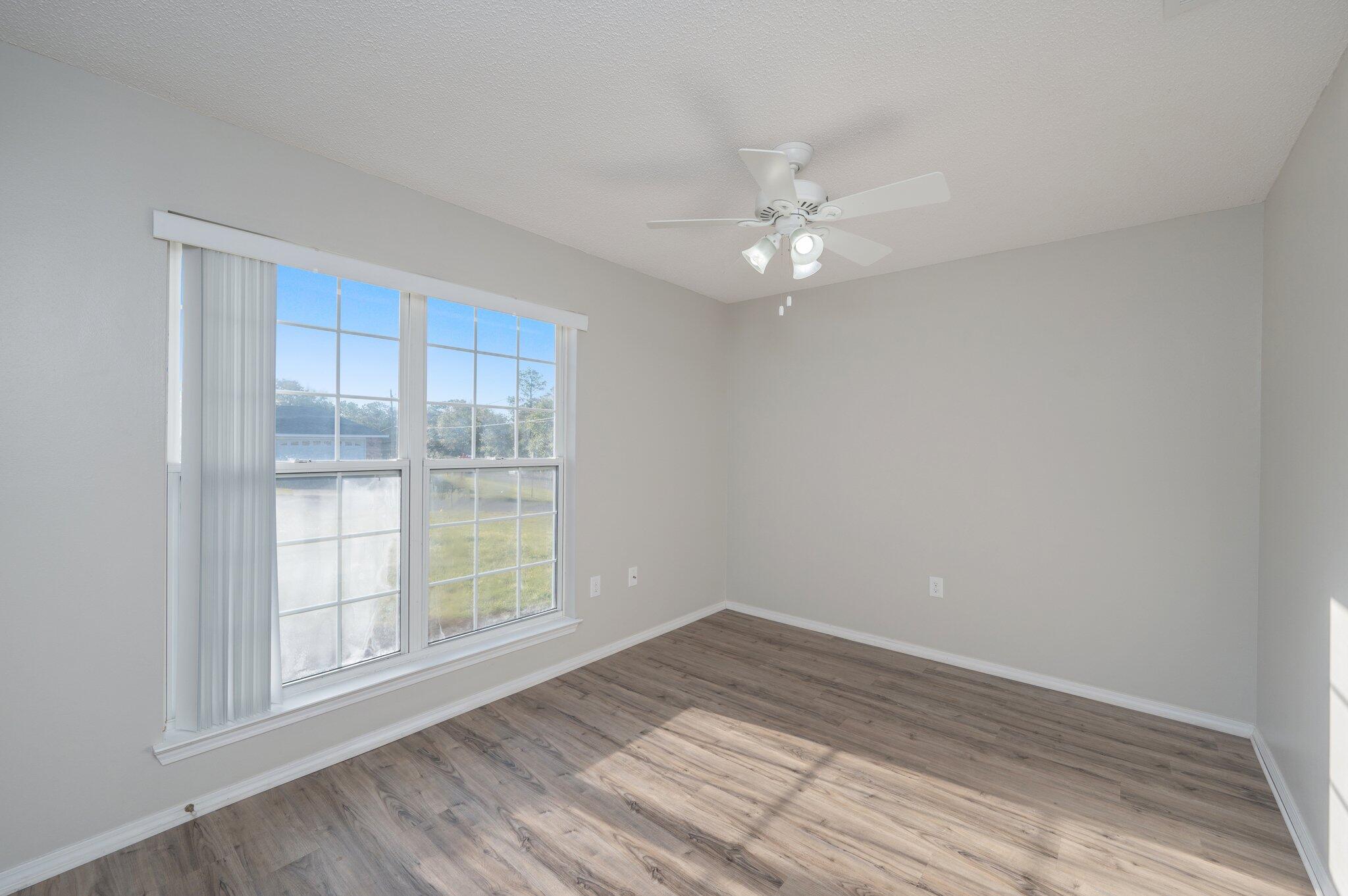 903 Twain Lane Crestview, FL 32536 - Photo 34 of 58 wooden floor in an empty room with a window