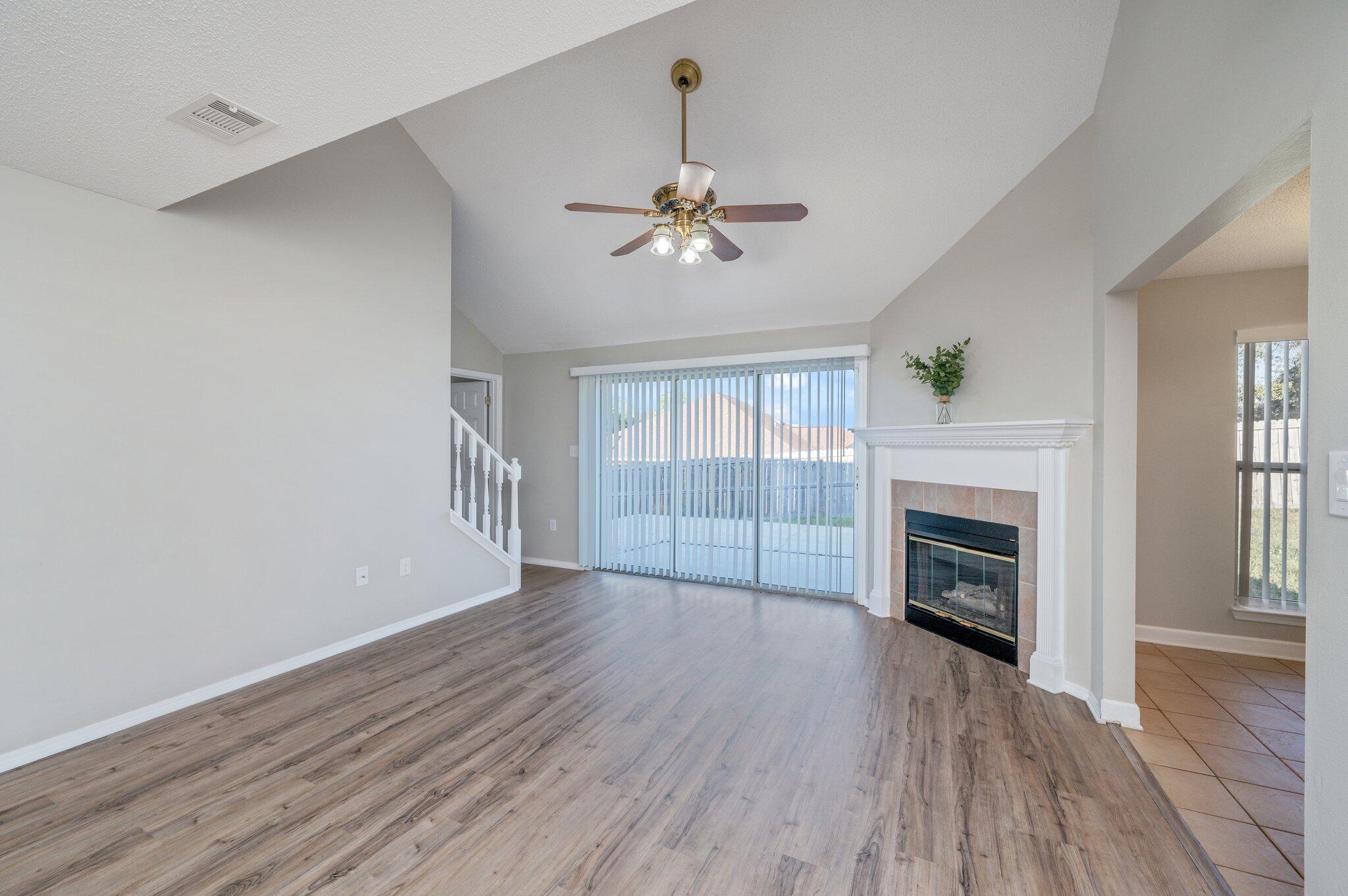 903 Twain Lane Crestview, FL 32536 - Photo 6 of 58 wooden floor in an empty room with a fireplace