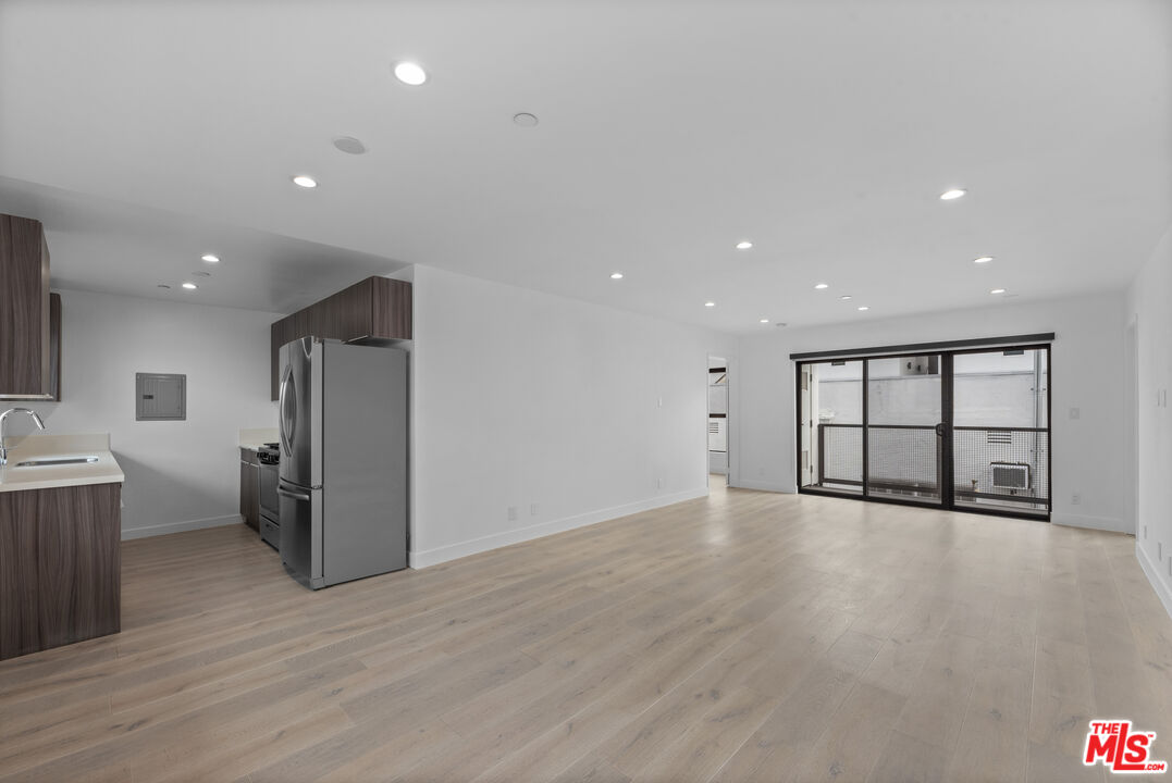 725 North Alfred Street, Unit 202 Los Angeles, CA 90069 - Photo 4 of 28 an empty room with wooden floor and windows