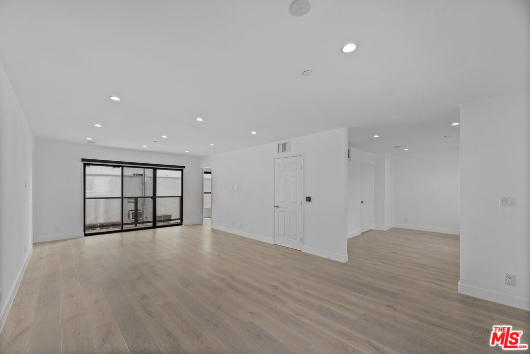 725 North Alfred Street, Unit 202 Los Angeles, CA 90069 - Photo 6 of 28 a view of an empty room with wooden floor and a window